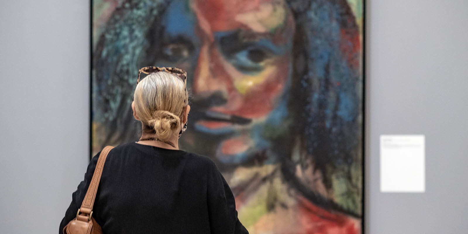 woman staring a painting at El Museo