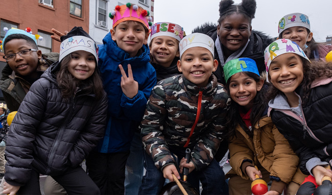 A group of smiling children wearing paper crowns